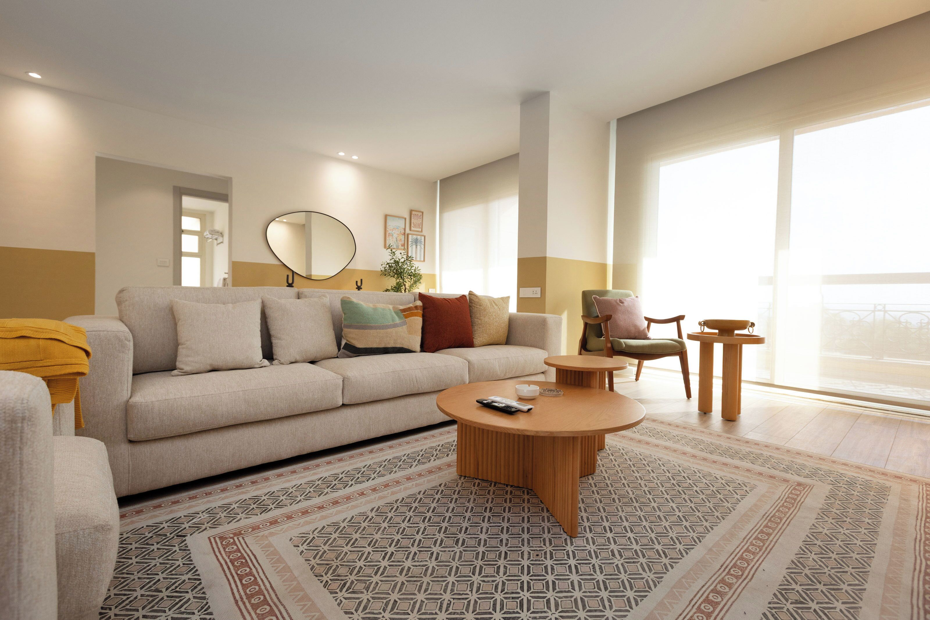 A modern living room with a sofa, coffee table, and a view of the outdoors.