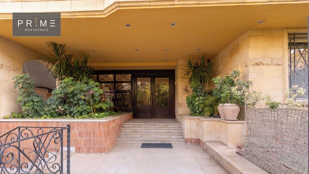 A hotel entrance with a covered walkway, potted plants, and a sign reading "PRIME RESIDENCE". - Prime Residence Golf Kattameya (Shurtah al-Dakhlah)