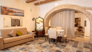 Una sala acogedora con sofá, una mesa de comedor y un espejo grande.