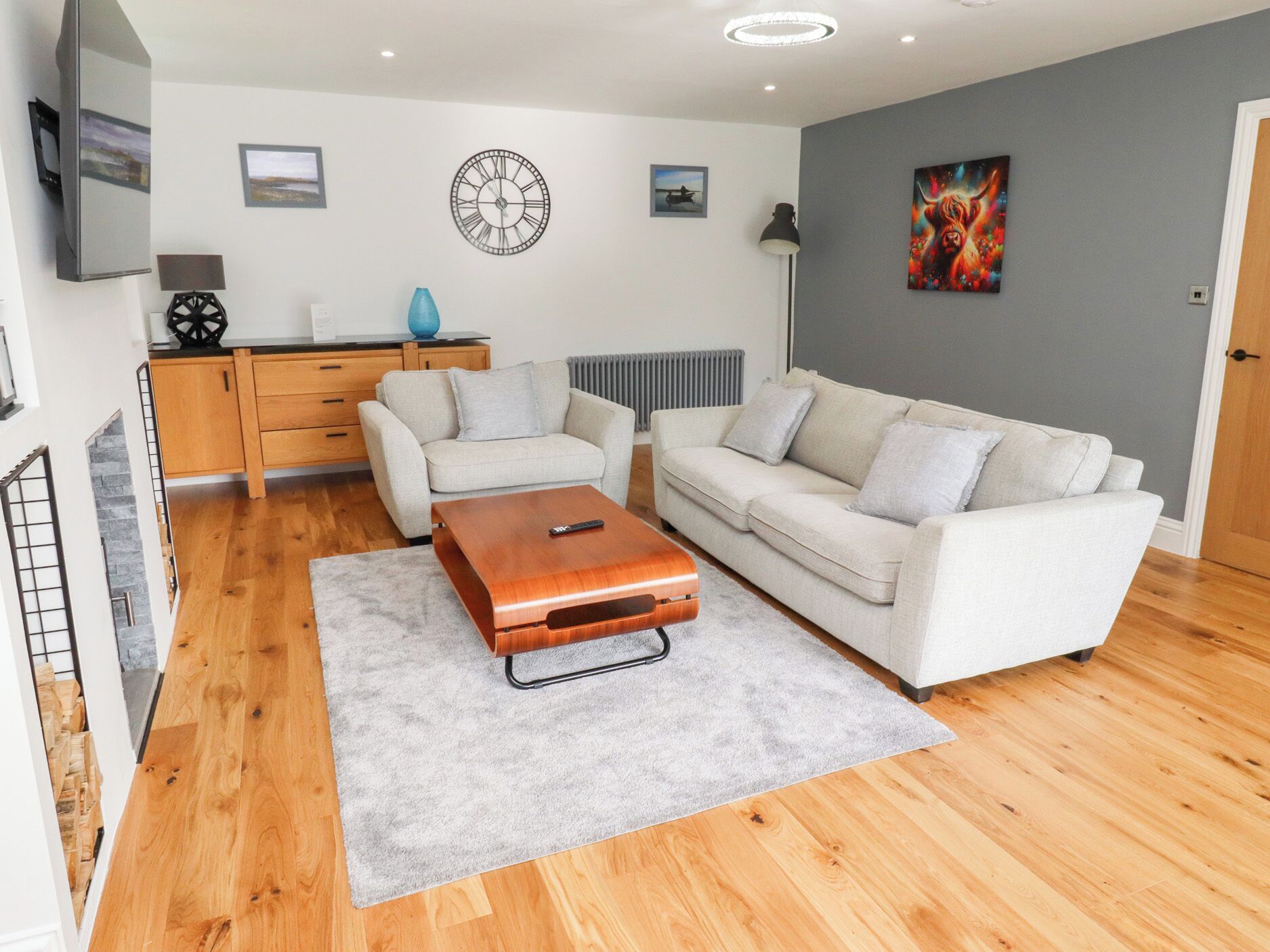 A modern living room with a sofa set, a coffee table, and a TV on a wooden cabinet.