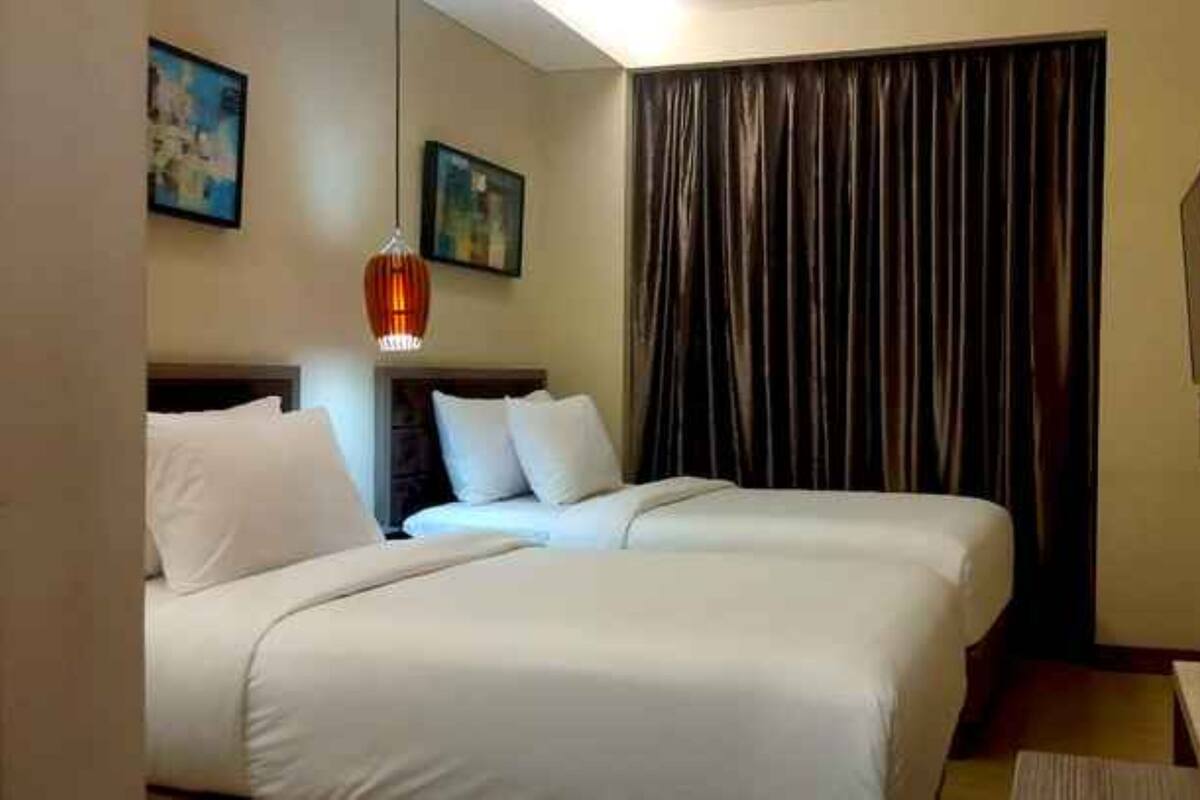 A hotel room with two beds, a large window with curtains, a flat-screen TV, and artwork on the walls.