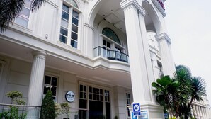 A white building with large windows and a balcony. There is a sign that says "Drop off lobby". - Caspella Suites Hotel Kemayoran (Jakarta)