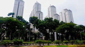 A row of high-rise residential buildings with a park in the foreground. - Caspella Suites Hotel Kemayoran (Jakarta)