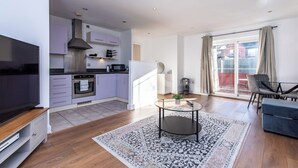 Un appartement moderne doté d’une cuisine, d’un coin repas et d’un balcon.