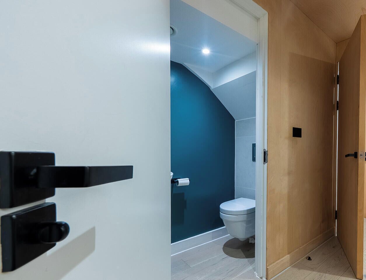 A modern bathroom with a toilet, a shower, and a glass door.