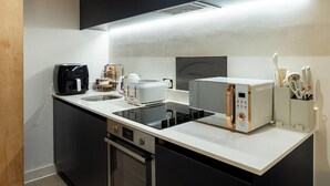 Une cuisine moderne équipée d’un four encastré, d’une machine à café et d’un grille-pain.