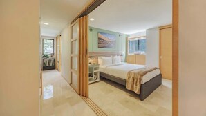 A modern bedroom with a large bed, a bedside table, a nightstand, a window, and a painting on the wall. - EP|  3 bed/ Br Apt W/city views, Great Location (Medellín)