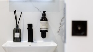 A bathroom sink with two bottles of hand wash soap and a diffuser. - Camden | Room B3 - Studio Apartment, Sleeps 2 (London)