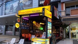 Un kiosque appelé « Freedom House & Backpack Bar », doté d’un panneau indiquant « Service d’information touristique ».