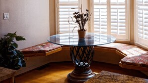 A corner dining area with a glass table, a vase with flowers, and a wall-mounted clock. - Waterfront Elegance (Discovery Bay)