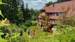 A traditional chalet with a sloped roof, wooden balconies, and a well-maintained garden.