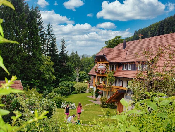 Un chalet tradicional con techo inclinado, balcones de madera y un jardín bien cuidado.
