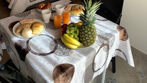 Een hotelkamer met twee bedden, een eettafel met ontbijt en een klein zithoekje.