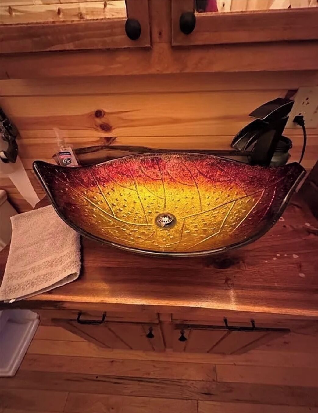 A wooden countertop with a decorative glass sink.