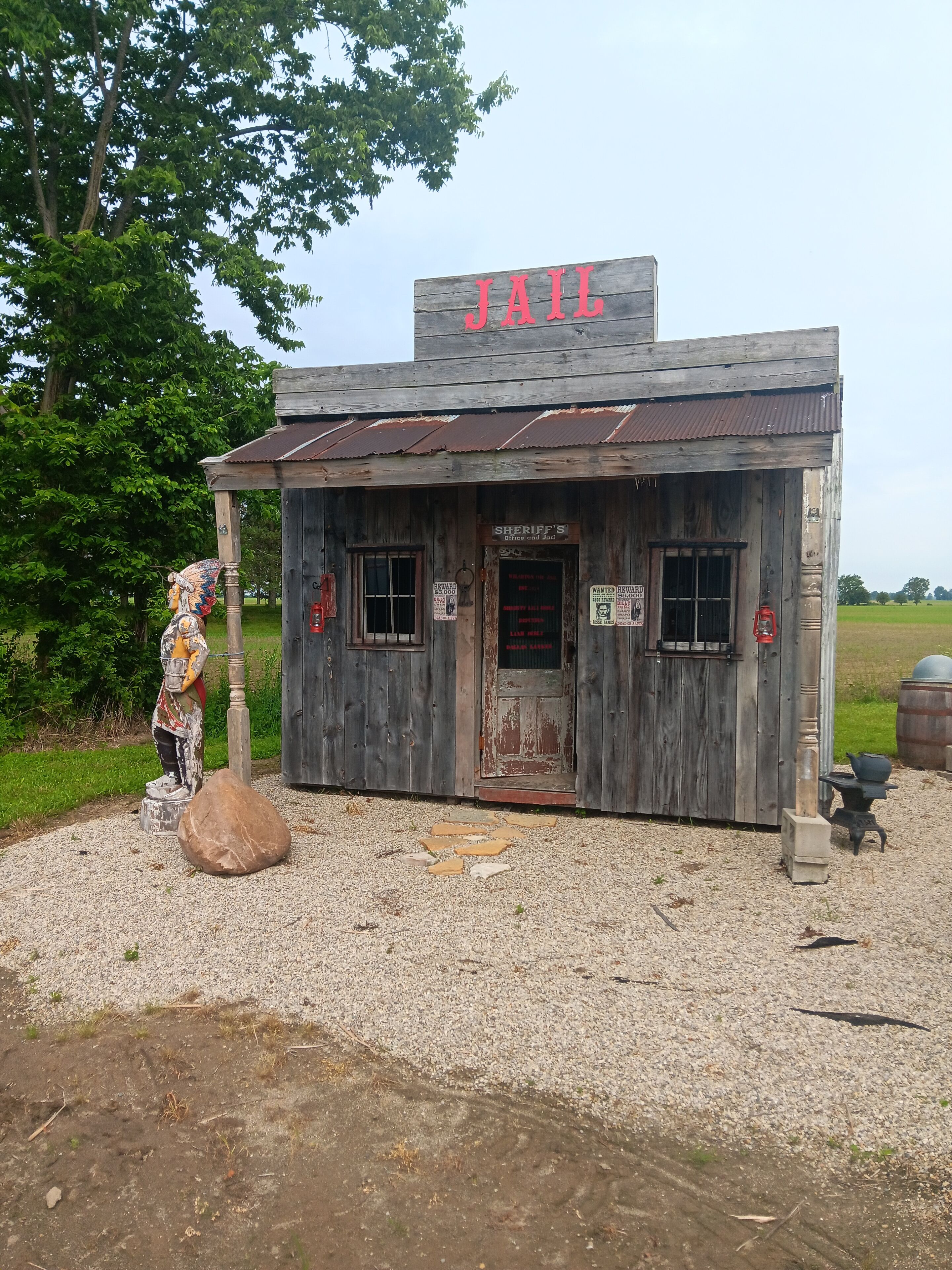Ein rustikales Gefängnisgebäude mit einer Holzfassade und einem Schild mit der Aufschrift „JAIL“ oben.