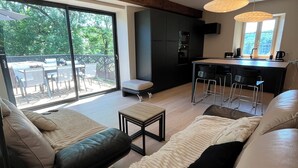 Una sala de estar moderna con un sofá, una mesa de centro y una zona de cocina con una mesa de comedor.