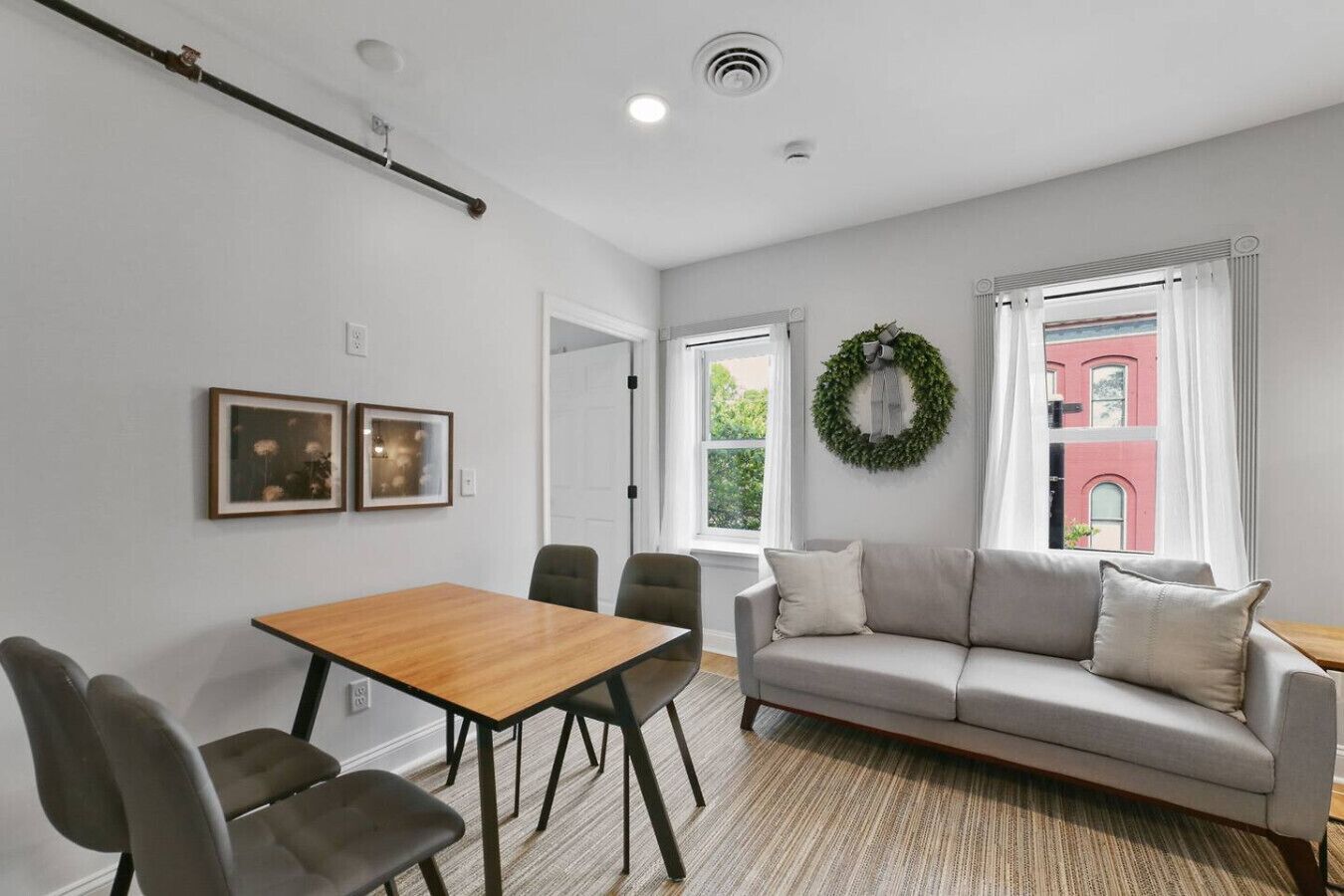 Un salon moderne comprenant un canapé, une table à manger, des chaises et une cheminée.