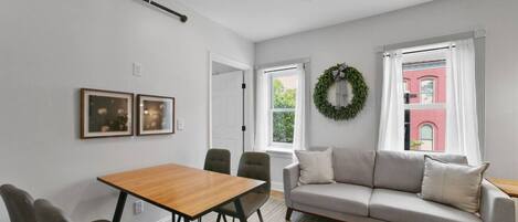 Un salon moderne comprenant un canapé, une table à manger, des chaises et une cheminée.