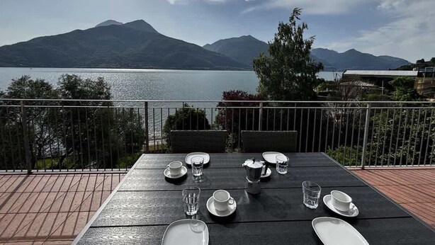Mesa para cuatro con vista a montañas y un lago.