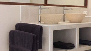 Une salle de bain avec deux lavabos, un miroir et un porte-serviettes avec deux serviettes.