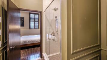 Ein Hotelzimmer mit einem Bett, einer Dusche und einer Holztür.