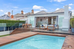 Ein modernes Haus mit Swimmingpool, Außenbereich und einer gläsernen Veranda.