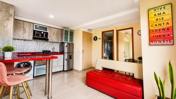 A compact living space with a kitchenette, a red sofa, and a dining area. - Laureles elegant Spring City Treat  (Medellín)
