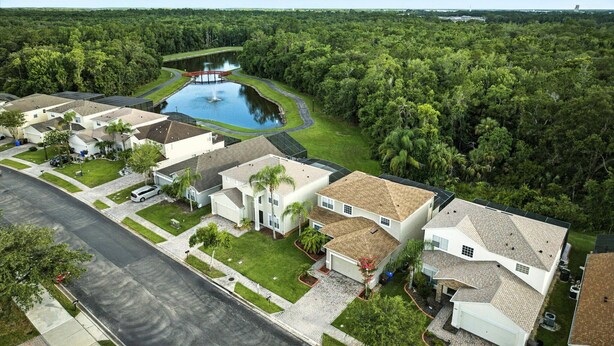 A residential area with houses, a central pond, and surrounding greenery. - 5 Bedroom Pool Home in Gated Community Near Disney (Kissimmee)