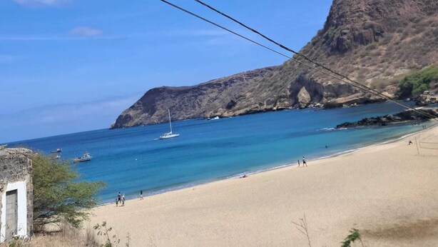 A beach with a rocky cliff and a stone bridge. - Casa de nonoiluzia (Tarrafal)