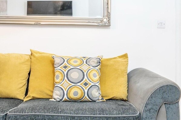 A grey sofa with two yellow cushions and a patterned cushion. - Luxury Central London Balcony 1-bed Apt w/ Parking (London)