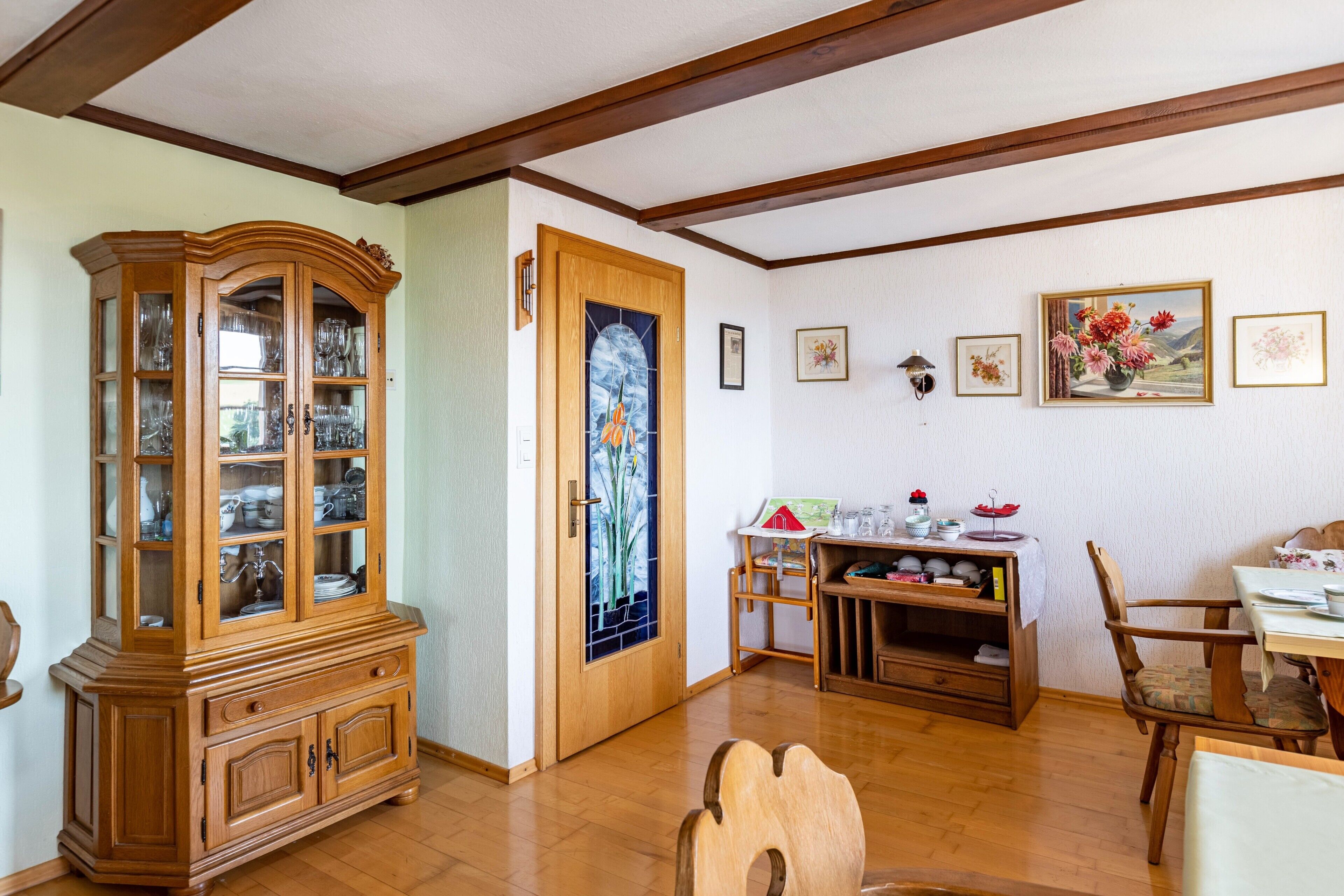Un coin repas avec des meubles en bois, un buffet et des œuvres d’art accrochées au mur.
