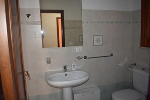 A bathroom with a sink, mirror, and toilet. - Naxos nature apartments (Giardini Naxos)