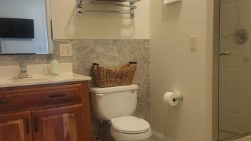 A bathroom with a toilet, sink, and shower.