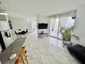 Un espacio moderno para vivir con cocina, comedor y un balcón con vistas.