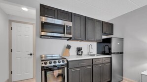 A compact kitchen with a stove, microwave, sink, and refrigerator. - One Block to the Boardwalk! (Seaside Heights)