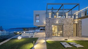 A modern house with a stone facade, a balcony, and a view of the sea. - Design villa with immaculate views in Theologos (Theologos)