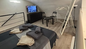 A small, compact room with a bed, a desk, a chair, and a TV. - Casa Angelina - Cozy stay near the most beautiful destinations in Puglia (Molfetta)