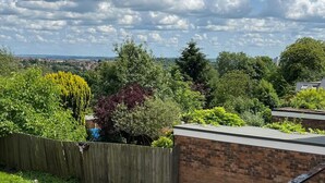 A residential area with a wooden fence, a brick wall, and various trees. - Nottingham 2-bed House, Sleeps 4, Pet Friendly (Nottingham)