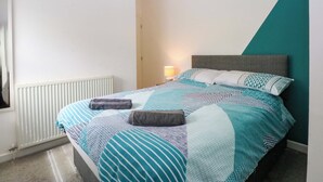 A bedroom with a bed, a bedside lamp, and a radiator.