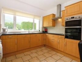 Una cocina con armarios de madera, una campana extractora de acero inoxidable y un horno doble.