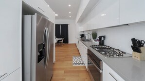 Een moderne keuken met roestvrijstalen apparatuur, een gasfornuis en witte keukenkastjes.