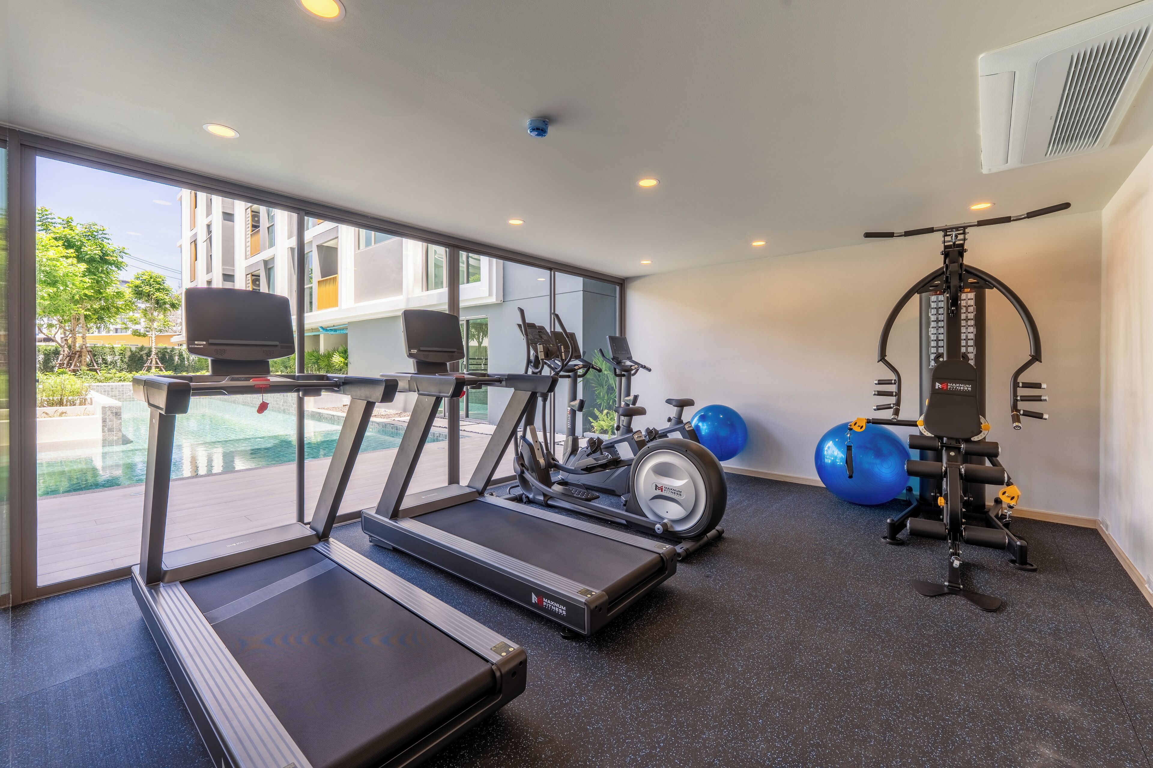 A gym with treadmills, stationary bikes, and exercise equipment.