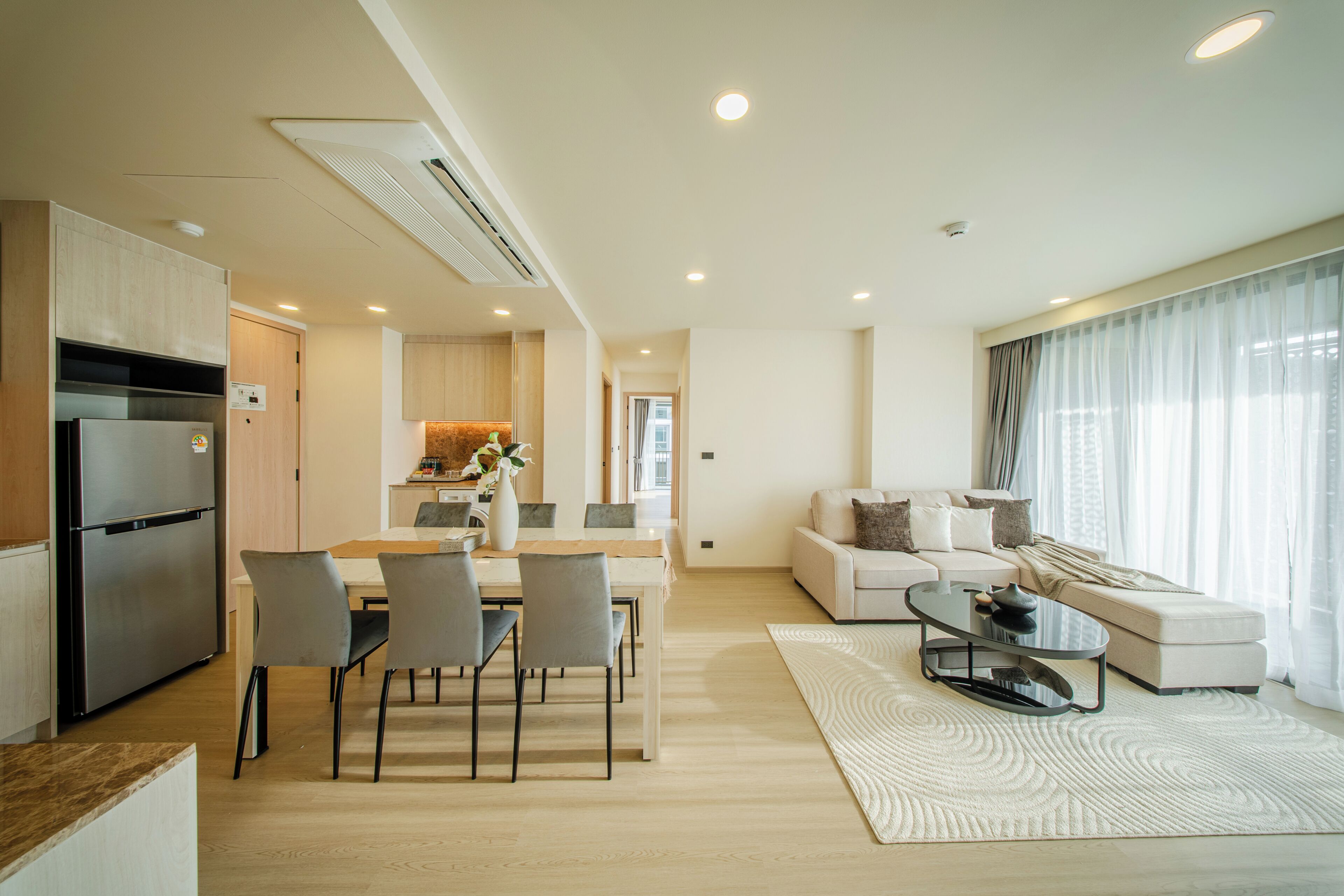 A modern apartment with a kitchen, dining area, and living room.