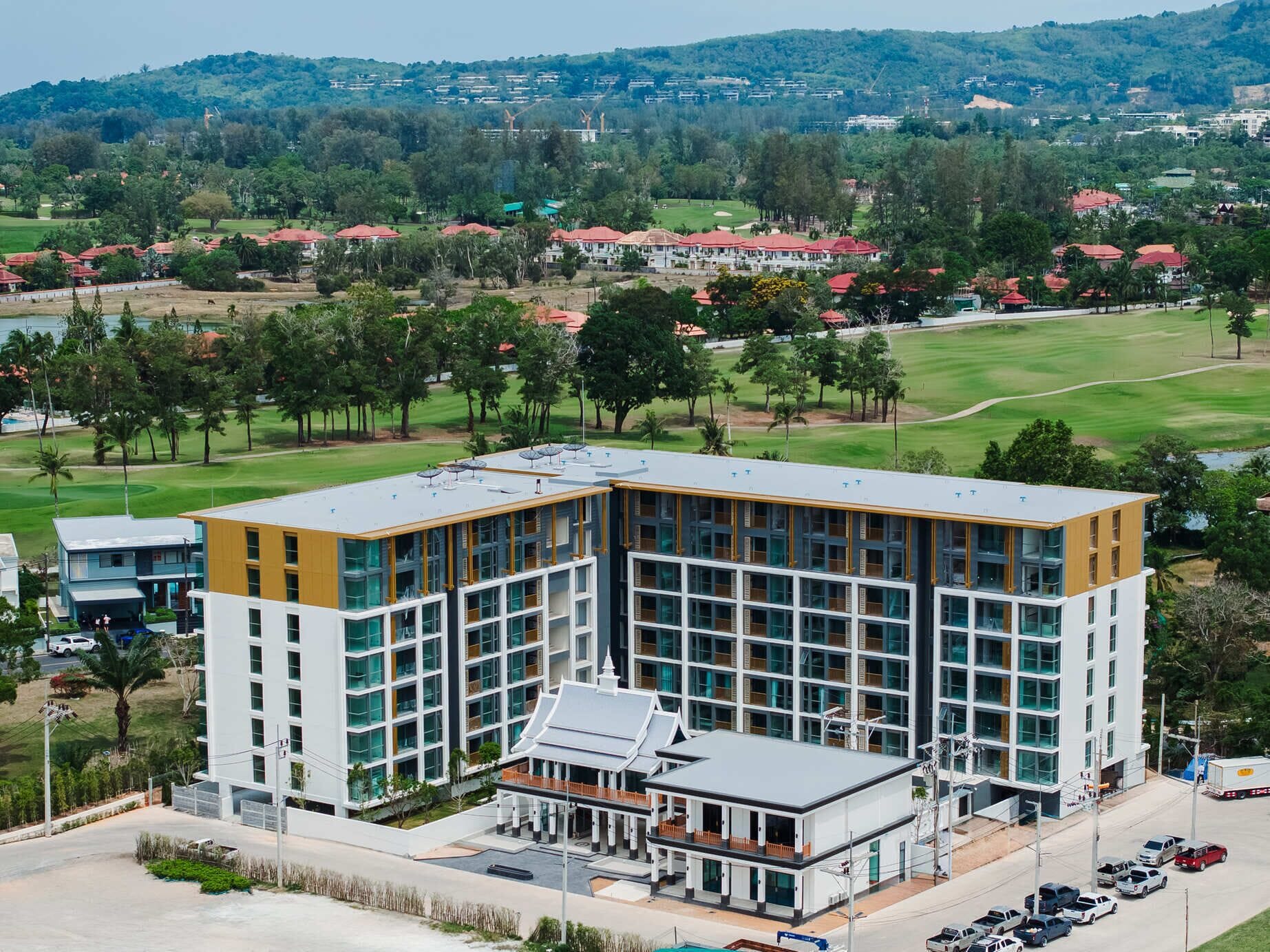 A modern hotel with a central courtyard, large windows, and a view of the surrounding landscape.
