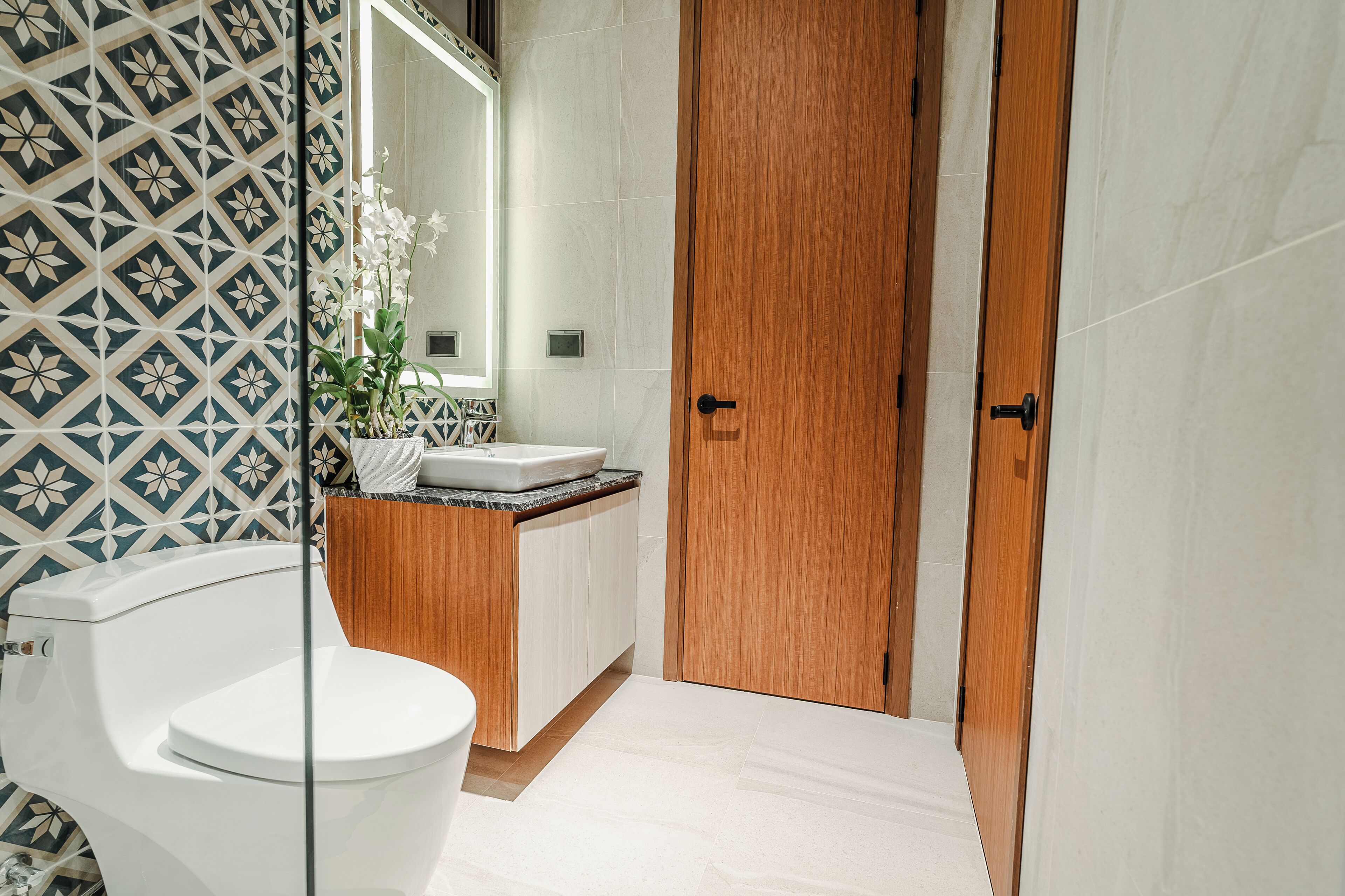 Un baño con inodoro, lavamanos y puerta de madera.