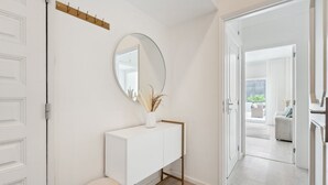 A modern bathroom with a white vanity, a round mirror, and a small stool. - GuestReady - An elegant stay in the city centre (Porto)