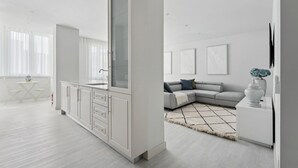 A modern, minimalist living space with a kitchen, dining area, and seating area.