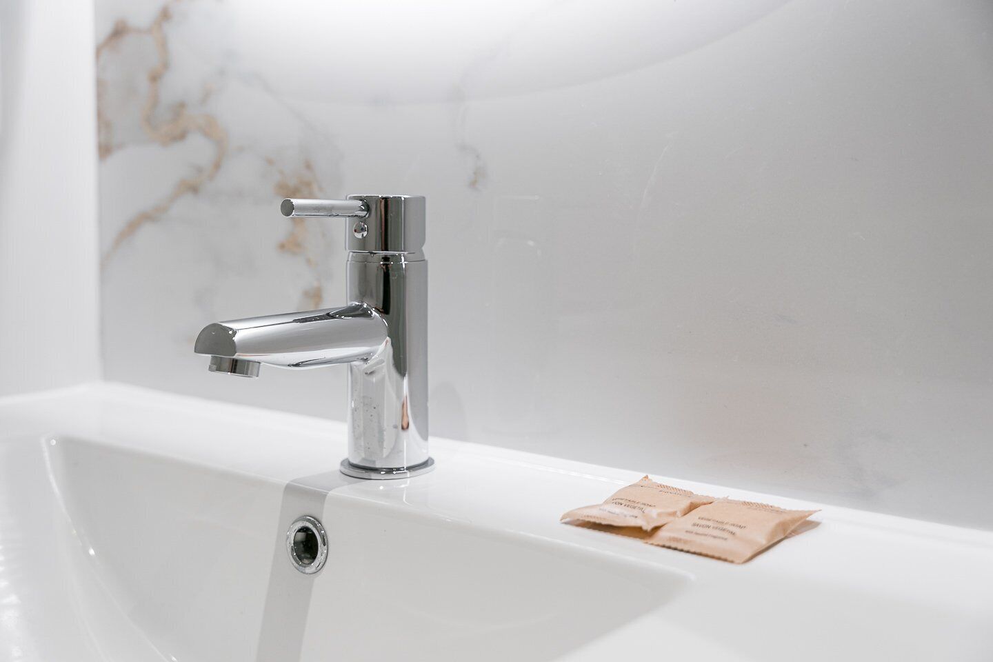 Une salle de bain moderne avec un robinet chromé et un lavabo blanc.