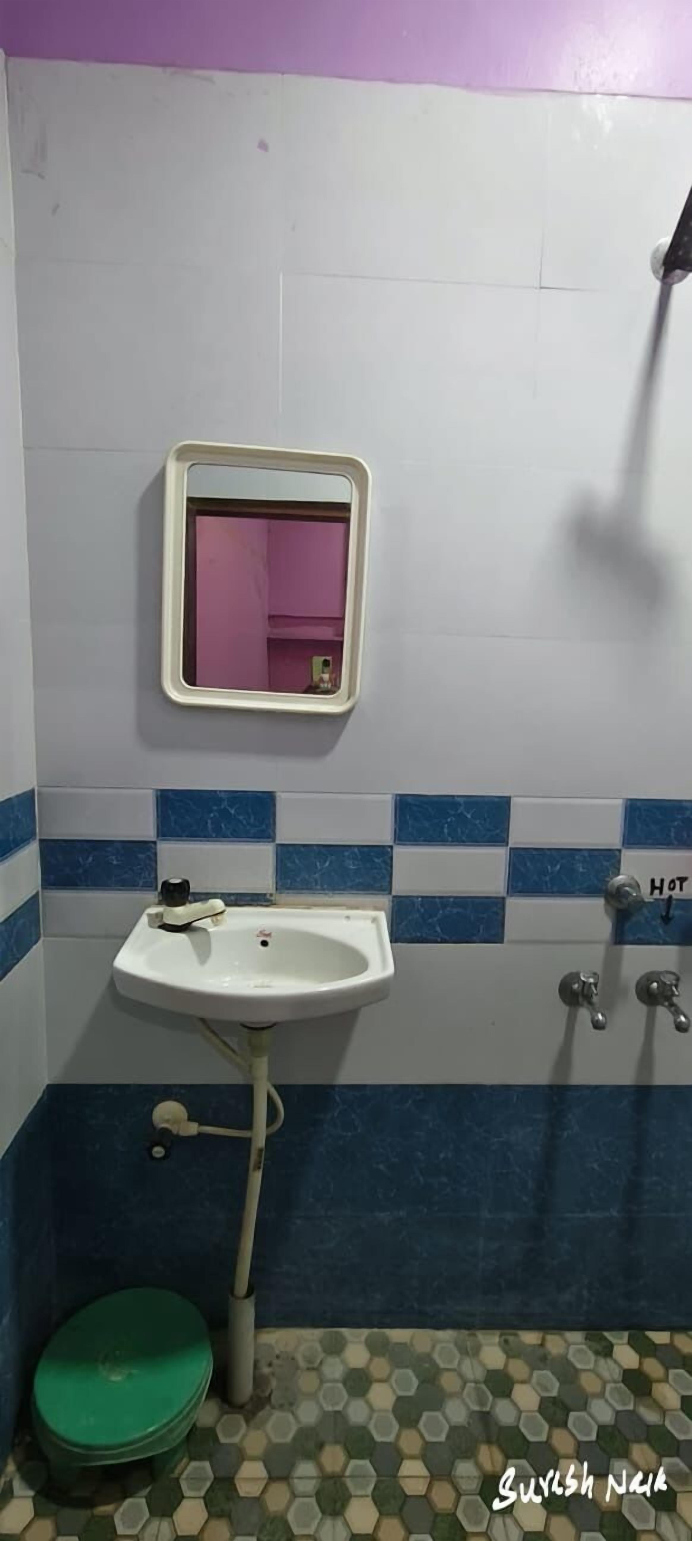 A bathroom with a white sink, a mirror, a toilet, and a shower.
