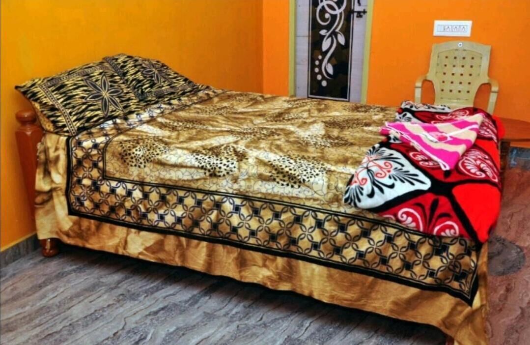 Una cama con una colcha estampada y un cojín decorativo.